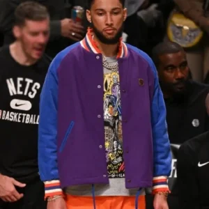 Ben Simmons NBA Brooklyn Nets Purple Bomber Jacket featuring a bold purple satin finish, ribbed cuffs and hem, snap-button front, Brooklyn Nets logo on the chest, and sporty striped detailing for a standout courtside look.