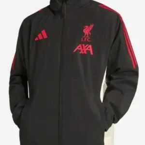 LFC Adidas 25/26 Domestic Rain Jacket: model wearing the Liverpool FC Adidas 2025/26 domestic rain jacket; features a red water-resistant shell with Club badge on chest, full-zip closure, adjustable hood, and sleek athletic fit designed for matchday performance.