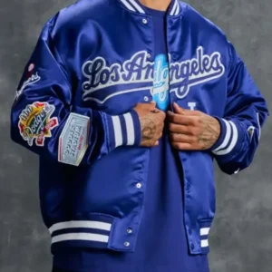 Model wearing the OVO x New Era x MLB Dodgers varsity jacket; features classic letterman styling with Dodgers and OVO branding, wool body with leather sleeves, ribbed cuffs and hem, and bold team patch detailing.