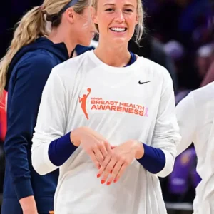 Sophie Cunningham Breast Health Awareness Sweatshirt in white with long sleeves, featuring a bold orange “Breast Health Awareness” graphic on the front, a silhouette of a woman holding a basketball, and a Nike logo on the chest.